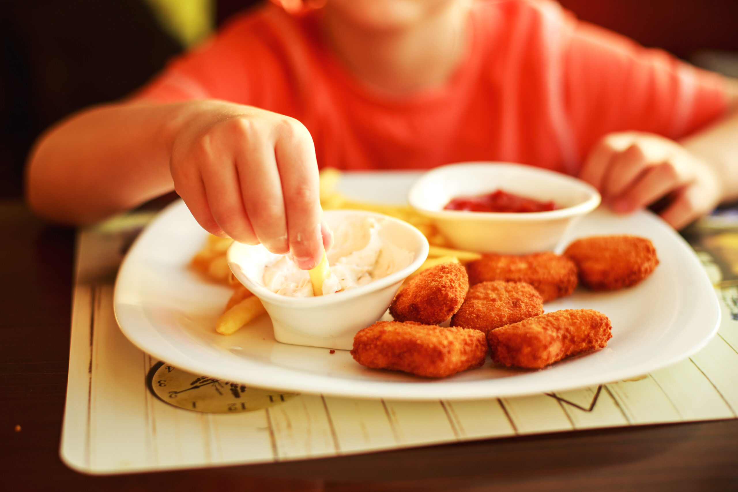 boy-eating-fast-food-in-a-cafe-the-child-eating-french-fries-with-nuggets