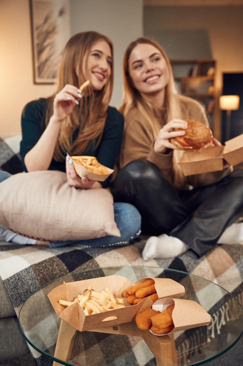 two-women-eating-chicken-nuggets-and-fries
