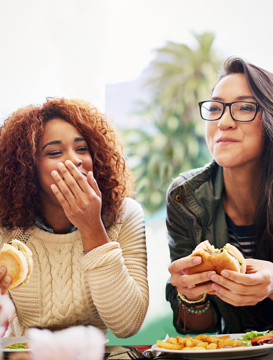 Two girls eating burgers and fries